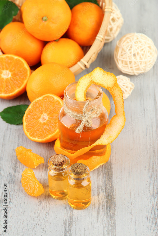 Tangerine essential oil and tangerines on wooden table