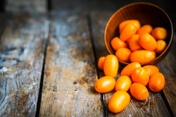 Canvas Print - Kumquat in a bowl on rustic wooden table