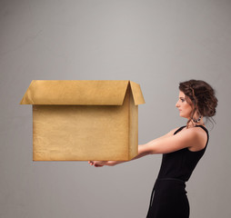 Young woman holding an empty cardboard box