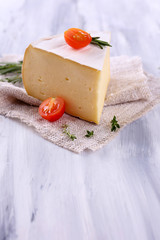 Tasty Camembert cheese with rosemary and tomato, on wooden