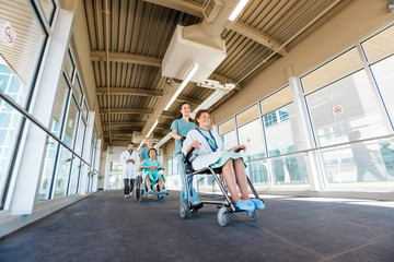 Wall Mural - Nurses Pushing Patients On Wheelchairs At Hospital Corridor