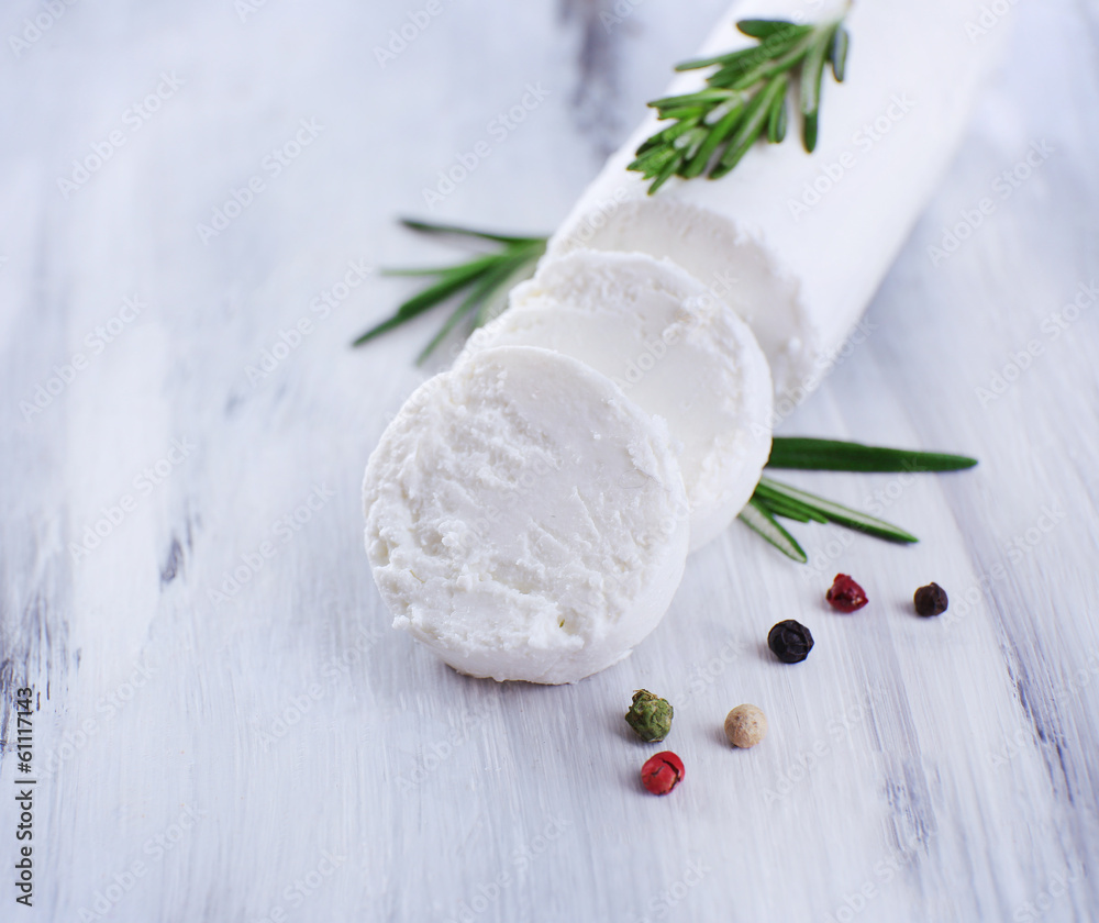 Tasty bushe cheese with rosemary, on wooden table