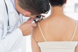 © WavebreakMediaMicro - Dermatologist examining mole on back of woman