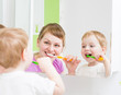 © Andrey Kuzmin - Happy mother and child teeth brushing  in bathroom front of mirr
