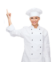 Poster - smiling female chef pointing finger to sonething