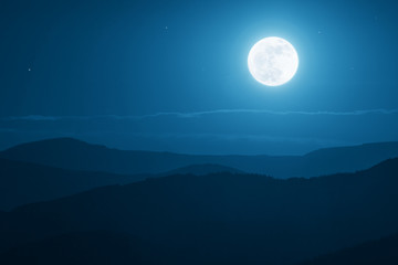 Wall Mural - dramatic mountain moonrise with deep blue sky and shadows