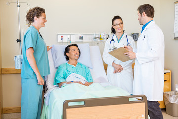 Wall Mural - Doctors Discussing Report While Nurse And Patient Looking At The