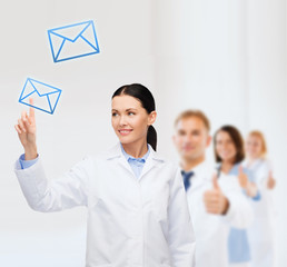 Poster - smiling female doctor pointing to envelope