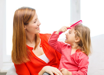 happy mother and daughter with comb