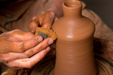 hands of a potter, creating an earthen jar