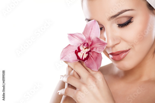 Plakat młoda kobieta z ręcznikiem na głowie pozowanie z orchidei