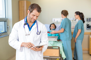 Wall Mural - Doctor Using Digital Tablet While Nurses Serving Breakfast To Pa