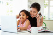 © Monkey Business - Busy Mother Working From Home With Daughter