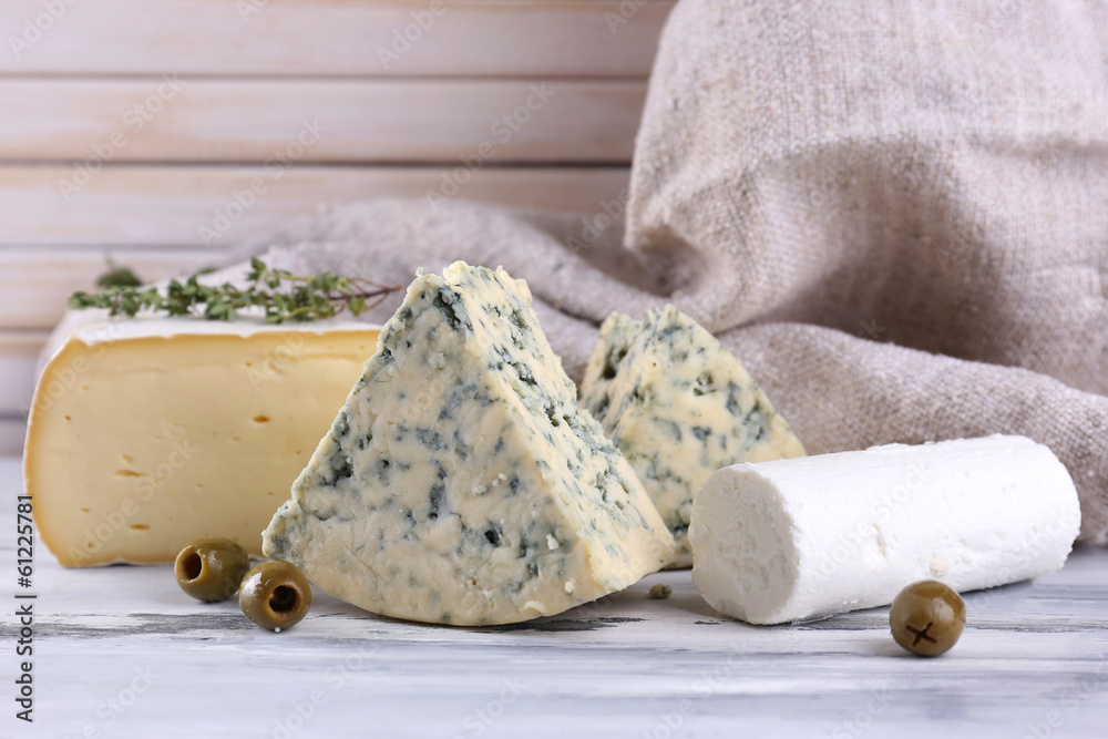 Different tasty cheese, on wooden table
