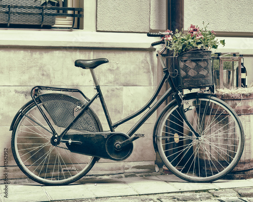 Naklejka na drzwi Vintage stylized photo of Old bicycle carrying flowers