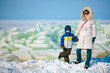 Young mother and her son on icy beach
