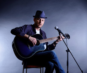 Poster - Young musician playing acoustic guitar and singing,