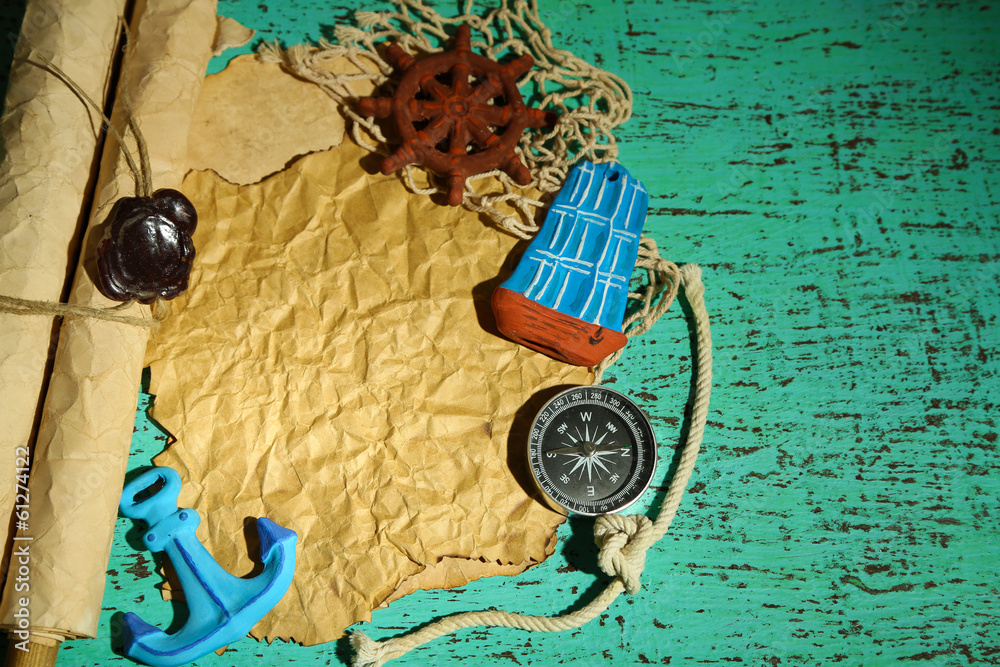 Old paper with sea accessories, isolated on wooden background