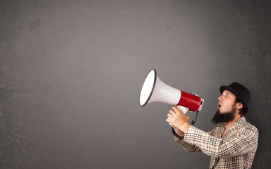 Guy shouting into megaphone on copy space background