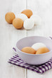 White and brown eggs in a lilac ceramic cup