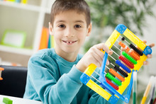 Young Boy At Home Working On The Abacus