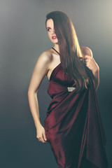 Beautiful fashion model poses with silk dress