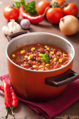 Wall Mural - mexican chili con carne in red rustic pot with ingredients