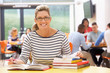 © micromonkey - Mature Female Student Studying In Classroom With Books
