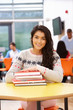 © micromonkey - Female Teenage Student In Classroom With Books