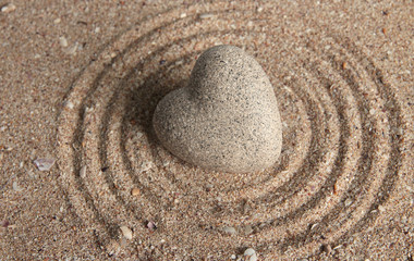 Wall Mural - Grey zen stone in shape of heart, on sand background