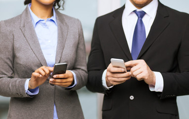 Wall Mural - businessman and businesswoman with smartphones