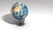 A realistic globe on a chrome pedestal over white B