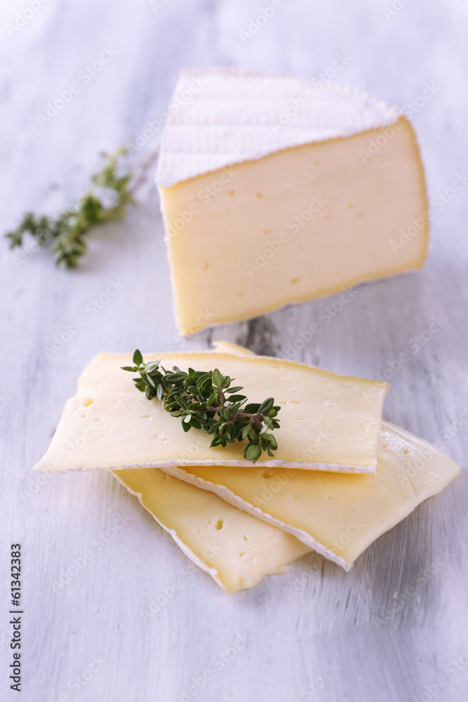 Tasty Camembert cheese with thyme, on wooden table