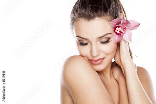 Naklejka na szybę beautiful young woman posing with orchid