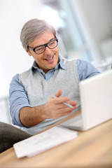 Wall Mural - Happy businessman reading good news on laptop