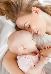 young mother and baby lying in bed