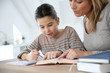 © goodluz - Mom helping kid with homework