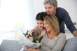 © goodluz - Family celebrating mother's day with bunch of flowers