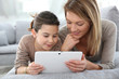 © goodluz - Mother and daughter playing with digital tablet