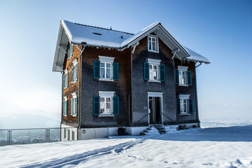 Snowy rustic austrian wooden house in morning light