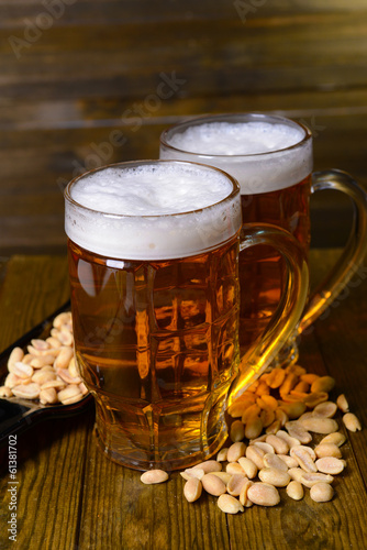 Fototapeta na wymiar Glasses of beer with snack on table on wooden background