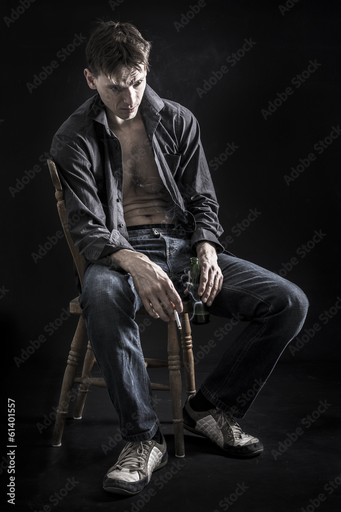 Depressed man on black background with cigarette Stock Photo