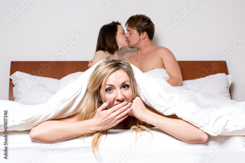 Photographie  Cheeky jeune femme dans un trio dans son lit