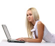 © lenets_tan - young business woman lying on the floor and working on a laptop