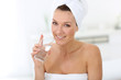 © goodluz - Attractive woman in bathroom drinking water