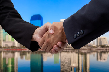 Businessman handshake with building background