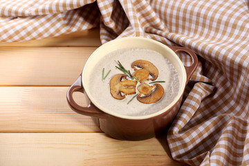 Canvas Print - Mushroom soup in pot, on napkin,  on wooden background