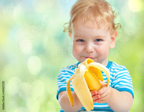 Fényképezés happy kid eating banana fruit. healthy food eating concept.