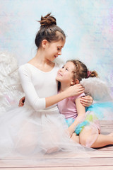 elder ballet dancer hugging her little sister