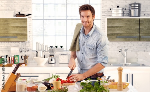 Fotomural Handsome man cooking in kitchen at home